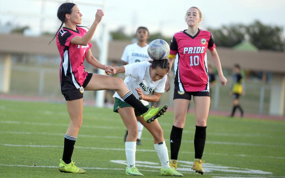 Kubasaki's Sakura Lopez heads the ball between Kadena's Baylee Smith and Lucy Delaney during Wednesday's Okinawa girls soccer match. The Dragons won 1-0.