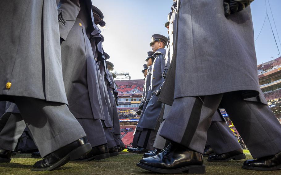 Cadets march, shown from field level, march into the stadium.