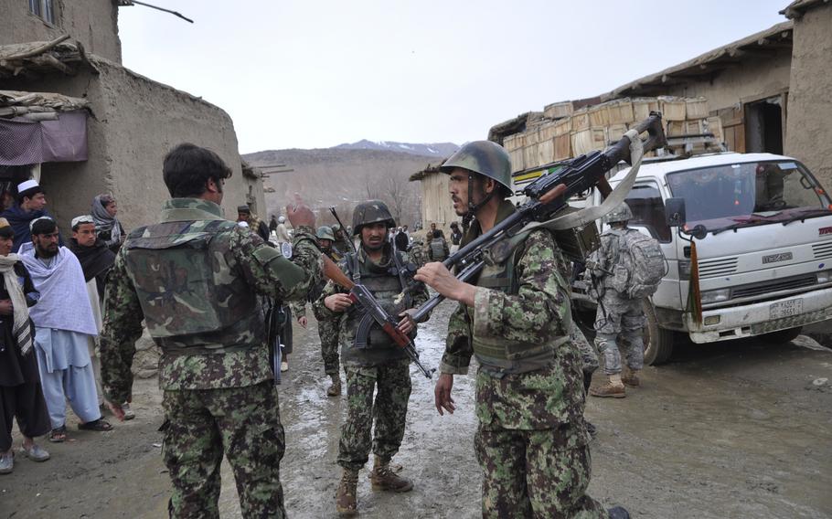 Afghan soldiers walk through the streets of Khanjankhel, in Wardak province, during a combined U.S.-Afghan air assault operation. The troops were responding to reports that Taliban fighters had been beating up villagers and had kidnapped two members of a U.S.-backed militia.