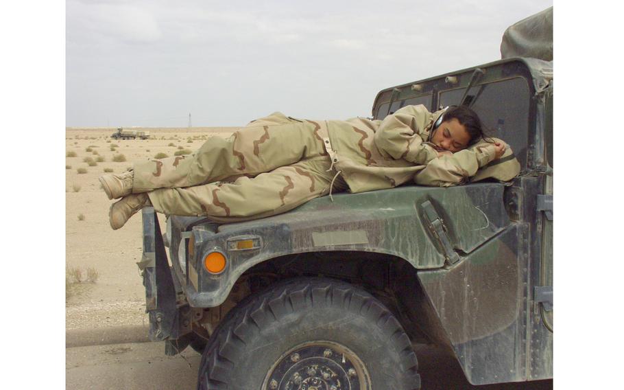 A soldier sleeps on a military vehicle