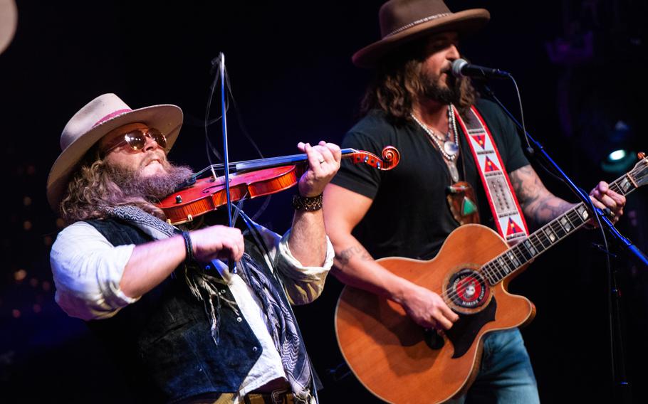 The country music duo War Hippies — Marine veteran and guitarist Scooter Brown, right, and Army veteran and violinist Donnie Reis, left — perform March 9, 2023, at MadLife Stage & Studios in Woodstock, Ga., just north of Atlanta. Brown and Reis both served in Iraq before embarking on music careers after leaving the military.