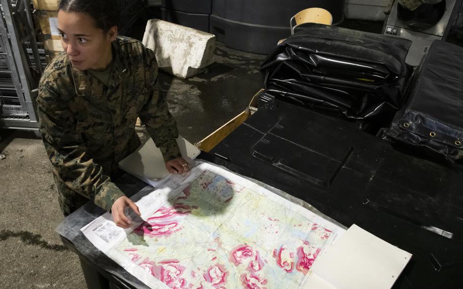 First Lt. Katie Hass, motor transport officer in charge, Combat Logistics Detachment, 3rd Battalion, 6th Marine Regiment, studies an avalanche map at Setermoen Military Camp, Norway, on Saturday, March 19, 2022.