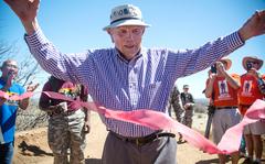Bataan Death March survivor, Col. Ben Skardon, 97, from Clemson, S.C., crosses the finish line for the eighth time during the Bataan Memorial Death March at White Sands Missile Range, N.M., March 22, 2015. Skardon marched 8.5 miles flanked by more than thirty supporters from "Ben's Brigade," friends and family who have marched with Skardon the past eight years and wear Clemson University Orange, Skardon's Alma Mater. (U.S. Army Photo by Sgt. Marcus Fichtl, 24th Press Camp)