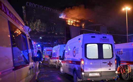Ambulances park near the burning Crocus City Hall on the western edge of Moscow on March 22, 2024.