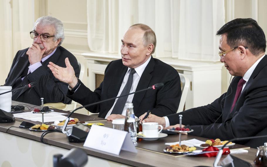 Russian President Vladimir Putin speaks into a microphone.