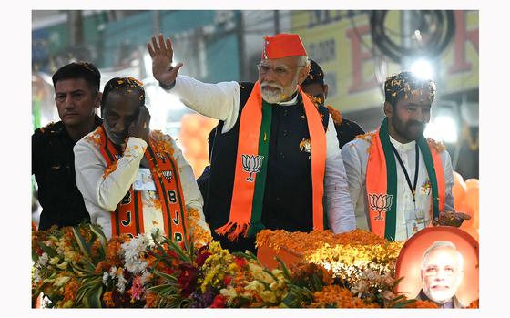India's Prime Minister Narendra Modi (center) waves to supporters during a road show as a part of Bharatiya Janata Party's (BJP) election campaign ahead of the Telangana state assembly elections, in Hyderabad on Nov. 27, 2023. (Noah Seelam/AFP via Getty Images/TNS)