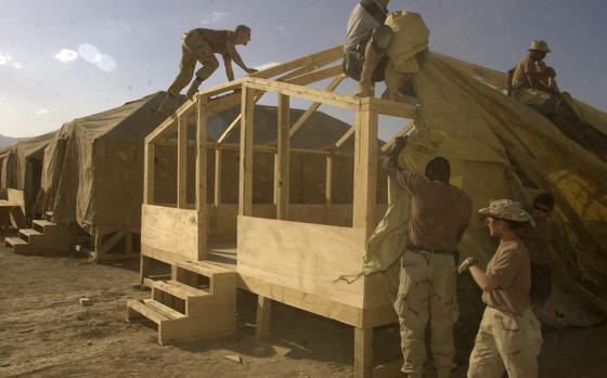 Bagram, Afghanistan, June 21, 2002: A patchwork team of airmen, soldiers and civilians put the finishing touches on what will become the living quarters for the 82nd Airborne.  Visit the Stars and Stripes store to order a copy of Stars and Stripes' photo book "15 years in Afghanistan," covering the years 2001 - 2016 https://www.stripesstore.com/15yearsinafghanistan-starsandstripesphotobook.aspx META TAGS: Operation Enduring Freedom, War on Terror, Afghanistan, U.S. Army, 82nd Airborne, 