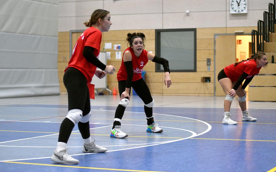 Red Team's Mia Snyder of Stuttgart, center, talks with teammate Maya Fitch of Vicenza, left, discuss tactics ahead of receiving a serve during a DODEA-Europe all-star volleyball match on Nov. 4, 2023, at Ramstein High School on Ramstein Air Base, Germany.