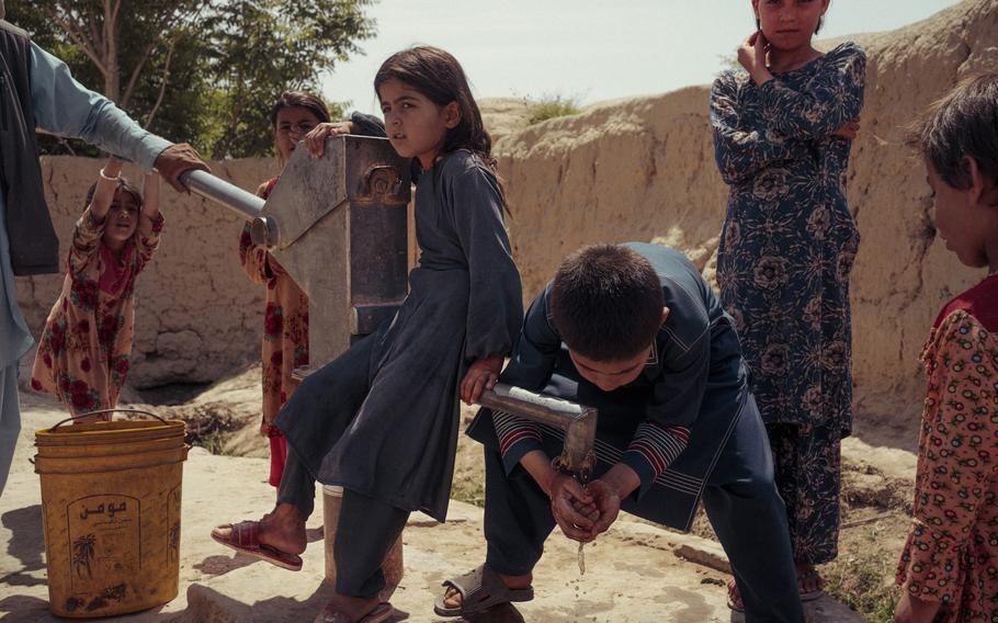 Children gather around a well to get water in the village of Qultagh. 