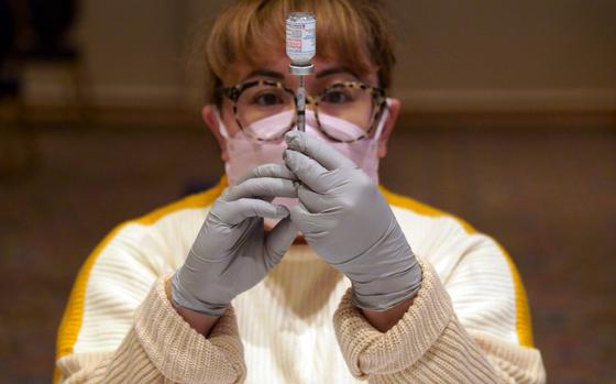 Laurie Fernandez, a nurse with Navy Medicine Readiness and Training Command at Yokosuka Naval Base, Japan, prepares a COVID-19 vaccine shot at the New Sanno Hotel in Tokyo, Feb. 16, 2022.