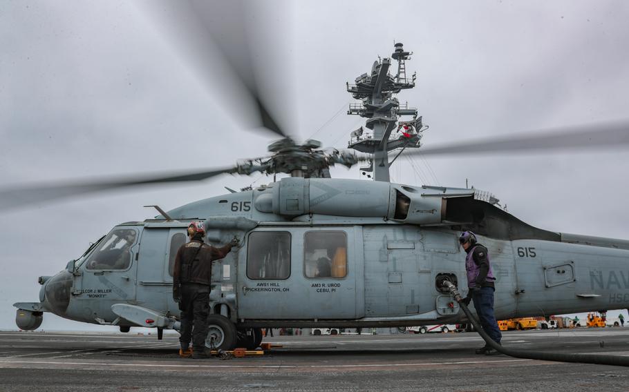An MH-60S Seahawk helicopter is refueled on the flight deck of the aircraft carrier USS Abraham Lincoln in the Pacific Ocean, Sept. 3, 2021.