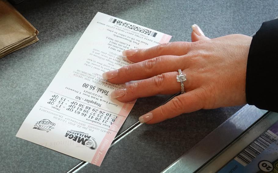 A customer purchases a Mega Millions lottery ticket at a 7-Eleven store in Chicago on Jan. 22, 2021. 