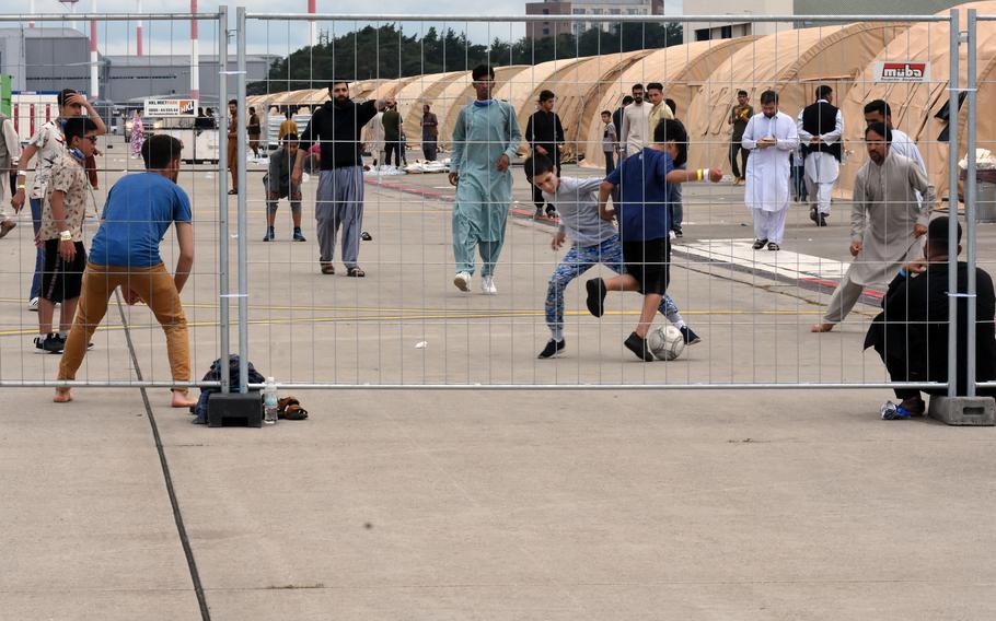 Men and boys play a game of soccer inside temporary living facilities set up for evacuees from Afghanistan on Ramstein Air Base, Germany, Aug. 23, 2021.