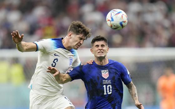 England's John Stones vies for the ball with Christian Pulisic of the United States, right, during the World Cup group B soccer match between England and The United States, at the Al Bayt Stadium in Al Khor , Qatar, Friday, Nov. 25, 2022.