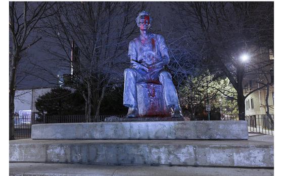 The Young Lincoln statue covered in red paint with the words “COLONIZER” and “LAND BACK!” written underneath in Senn Park in Chicago on Nov. 24, 2022.