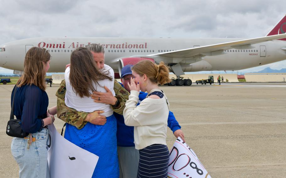 An airmen embraces his family