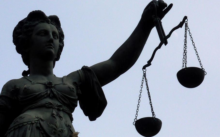A statue holds the scales of justice.