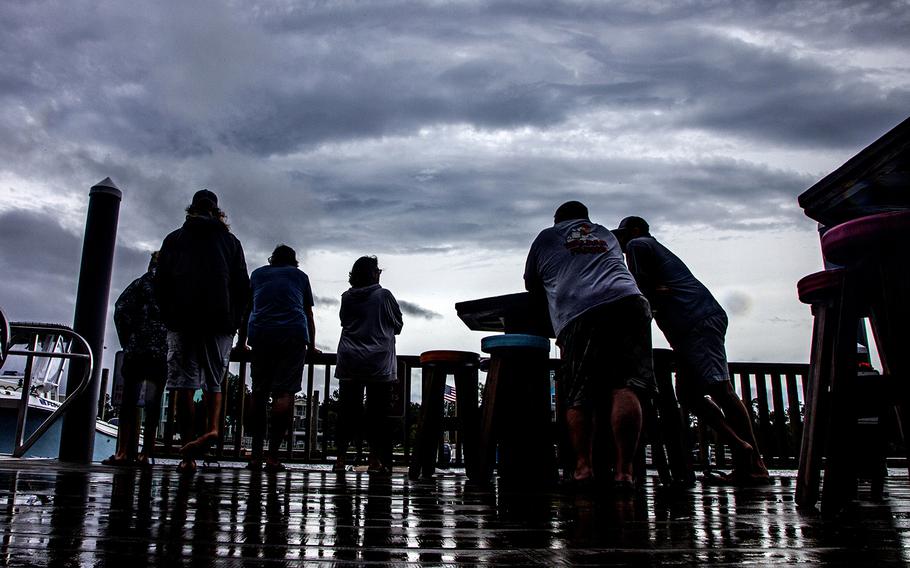 Spectators stand along the Steinhatchee River waiting on high tide at the Sea Hag Marina after Tropical Storm Elsa made landfall nearby on July 7, 2021, in Steinhatchee, Fla. 