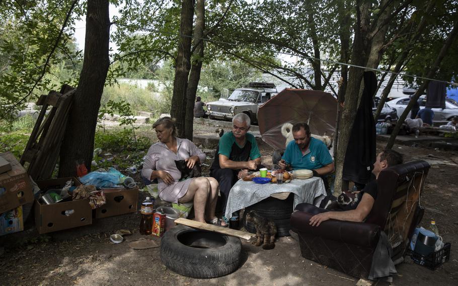 The Pestereva family from Mariupol as they eat lunch by the tent they have been staying in on the outskirts of the village of Kamiyanske, Ukraine on Aug. 27, 2022. The family fled their home in Russian-held Mariupol on April 5 but now want to return. 