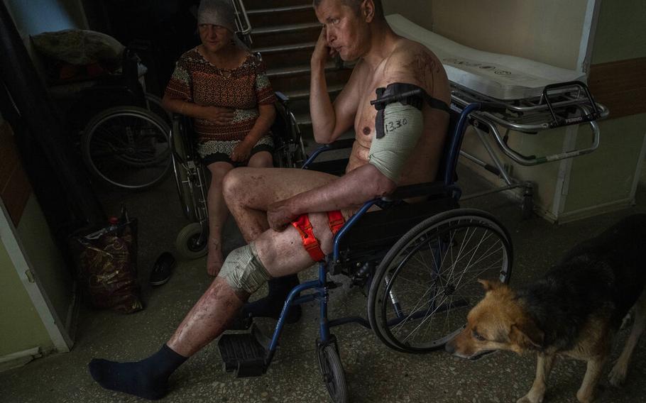 A Ukrainian injured serviceman and an injured civilian wait for medical treatment in the Donetsk region, eastern Ukraine, Tuesday, June 7, 2022. (AP Photo/Bernat Armangue)