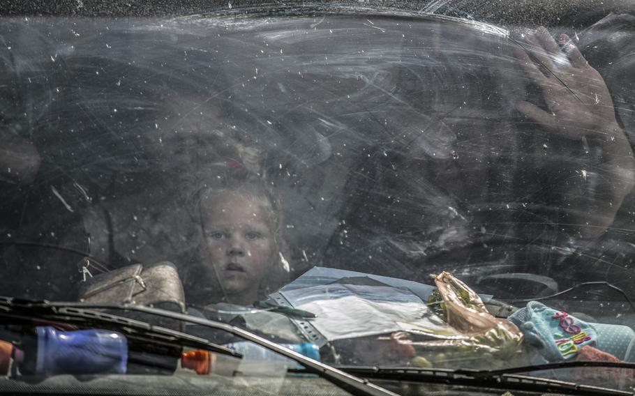 The Kassimya family from Melitopol as they wait in their vehicle for Ukrainian police to escort them after they arrived in a convoy with others to a staging area on the outskirts of the village of Kamiyanske, Ukraine, on Aug. 27, 2022. 