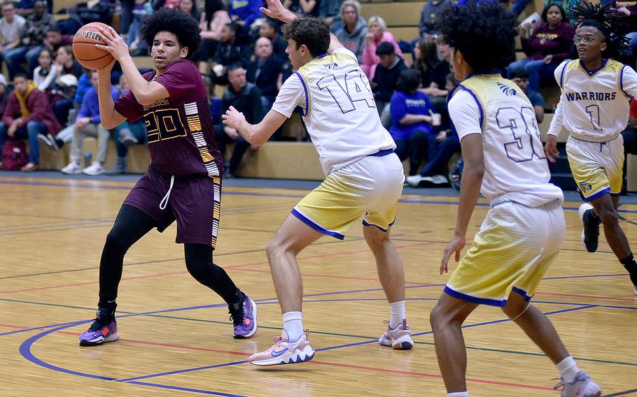 Baumholder's Dorian Cobb, left, looks to pass the ball during Friday evening's game against Wiesbaden at Wiesbaden High School. Defending are, are left, the Warriors' Collin Koschnik, Malfoy Anitok and Jordan Thibodeaux.