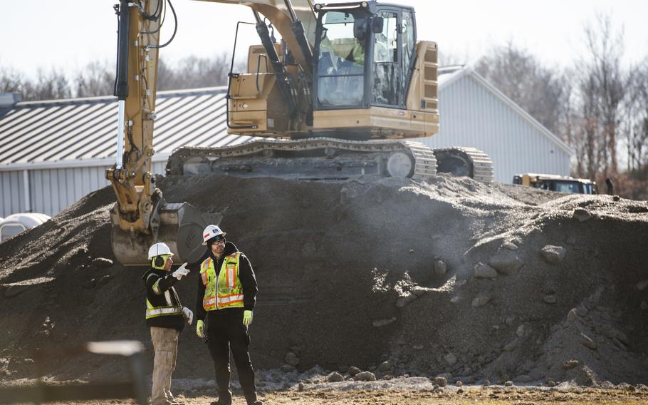 Alexander Lampe (left), Environmental Restoration quality control manager, and Brandon Gunia, DeWind foreman and operator, discuss strategy while a worker uses an excavator Nov. 21, 2022, to prep a pile of gravel at Wright-Patterson Air Force Base, Ohio. The trench being dug is part of an Area B construction project designed to help remove substances previously used in firefighting from groundwater.