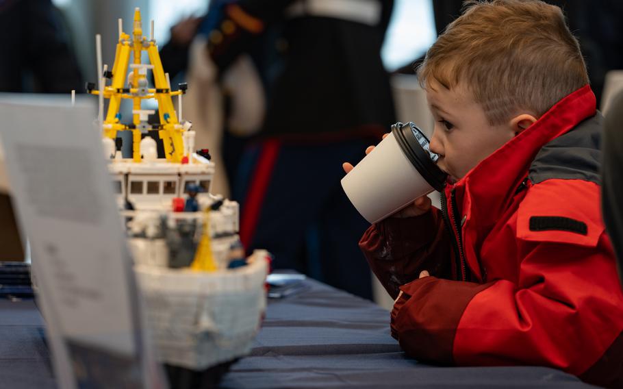 A child inspects a lego model of the newly commissioned Coast Guard Cutter Melvin Bell at the Coast Guard Academy in New London, Conn., March 28, 2024.
