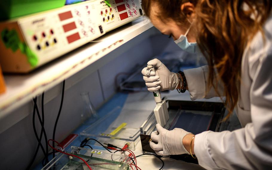 In this photo from Jan. 21, 2021, a laboratory technician wearing protective equipment works on the genome sequencing of the SARS-CoV-2 virus (COVID-19) and its variants at the Centre National de Reference of respiratory infections viruses of the Pasteur Institute in Paris. 