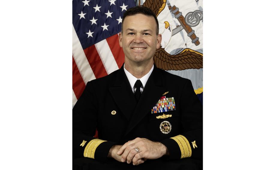 A Navy officer smiles for an official portrait