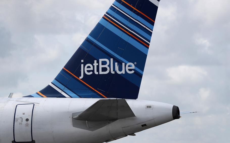 The tail of a JetBlue plane is seen as it prepares to take off in 2020. A woman on a JetBlue Airways Corp. flight from Miami to Los Angeles yelled at a flight attendant and slammed into his body, almost knocking him into a lavatory, according to the FAA. She is one of many passengers who have behaved badly on jets, often to little or no consequence to themselves. 