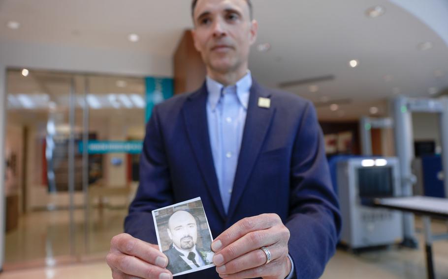 Anthony Gardner, public affairs specialist at the World Trade Center Health Program, holds a photo of his brother Harvey Joseph Gardner III, who died on Sept. 11, at “The Health Effects of 9/11” exhibit at the CDC Museum on Thursday, Sept. 7, 2023.