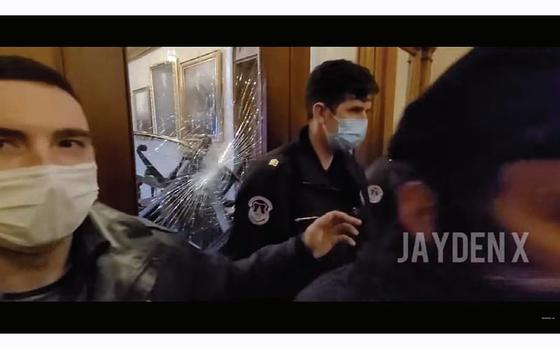 A screen grab of a video that John Earle Sullivan recorded on Jan. 6, 2021, shows officers in front of a partition outside the House chamber just moments before all the officers walked away from the area allowing protesters to further smash the glass through which Air Force Ashli Babbitt tried to crawl before Capitol Police Lt. Michael Byrd shot Babbitt from the other side. 