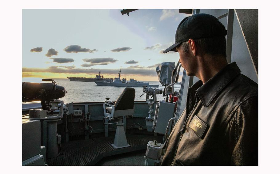 Lt. Cmdr. Andrew Grimm, watches as the Arleigh Burke-class guided-missile destroyer USS Sterett (DDG 104), the Republic of Korea Navy’s Sejong the Great (DDG 991), the Nimitz-class aircraft carrier USS Carl Vinson (CVN 70) and the Japan Maritime Self-Defense Force’s JS Kirisame (DD 104) sail together during a trilateral maritime exercise on Nov. 26, 2023.