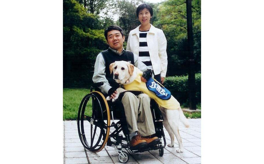 Yoshitomo Kimura, 61, with his wife and his first service dog, Cynthia. 