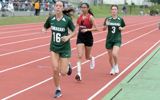 Kubasaki's Isabella Mabie (16) and Reyna Eastman (3) sandwich Kinnick's Lauren Cabradilla in the home stretch of the girls 3,200-meter run during Friday's Mike Petty Memorial Meet. Mabie and Eastman play soccer for the Dragons, but since the Petty is considered an open meet, they and eight other Kubasaki girls soccer players entered and competed. Mabie finished third in the event.