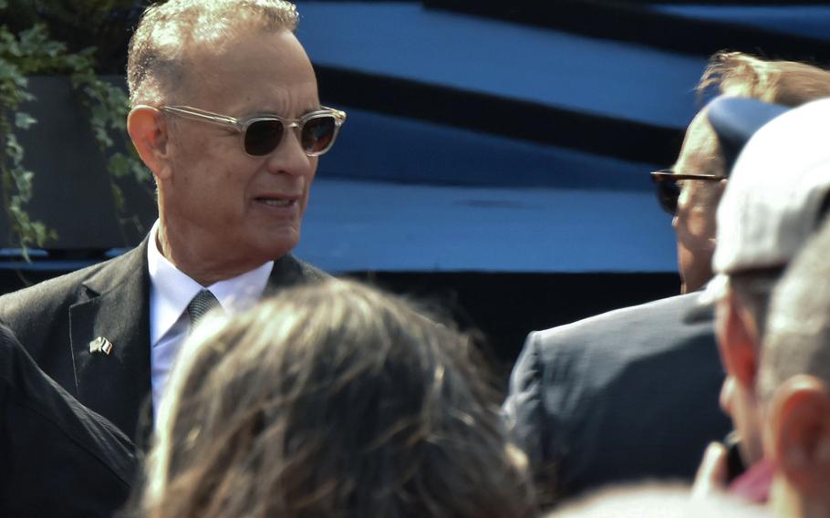 Tom Hanks speaks with other visitors before the D-Day 80th anniversary commemoration at Normandy American Cemetery in Colleville-sur-Mer, France, June 6, 2024.