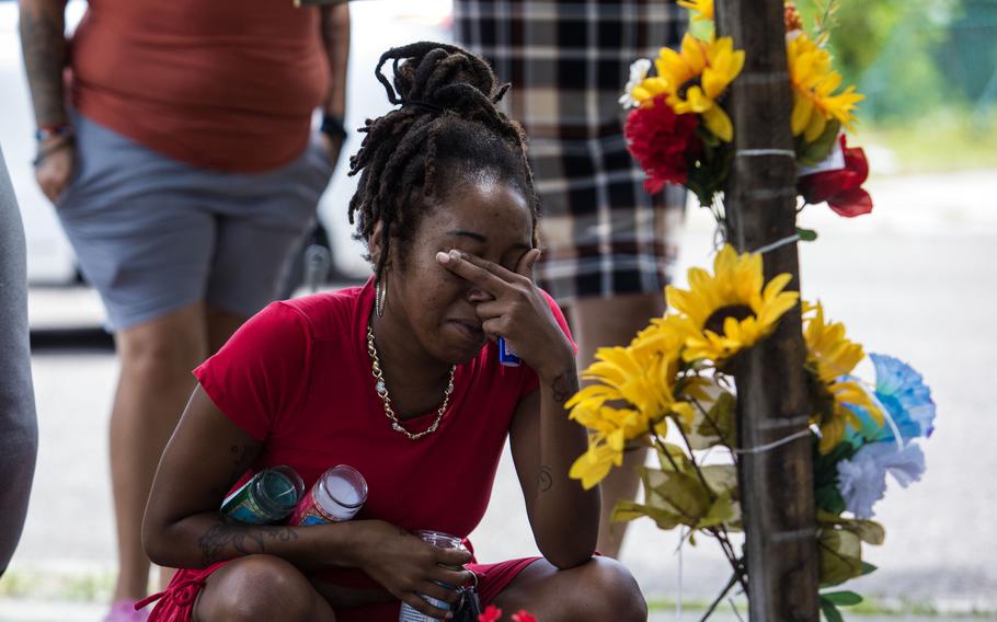A woman takes a moment in August at a makeshift memorial outside a Dollar General store in Jacksonville, Fla., where three people were fatally shot. 