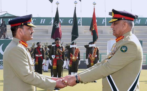 In this photo released by Army's public relations wing 'Inter Services Public Relations', Pakistan's outgoing Army Chief Gen. Qamar Javed Bajwa, right, hands over a ceremonial baton to his successor Gen. Asim Munir during the Change of Command ceremony, in Rawalpindi, Pakistan, Tuesday, Nov. 29, 2022. Pakistan's new army chief Munir, took command of the country's armed forces amid a deepening political rift between the government and the popular opposition leader, as well as a renewed threat from a key militant group that has been behind scores of deadly attacks over 15 years.