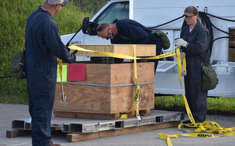 Blue Grass Chemical Activity personnel strap the last of the mustard overpacked projectiles onto a tray for loading into an enhanced on-site container.