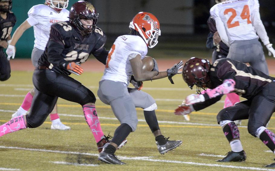 Kinnick running back Wendell Harrison gets sandwiched by Perry defenders Zeke Santoscoy and Shion Fleming.