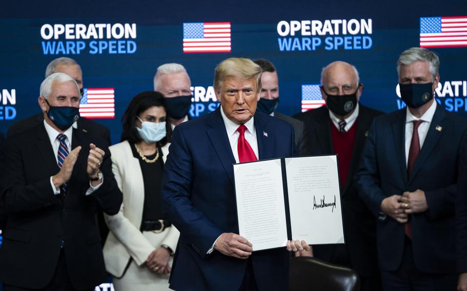 President Donald Trump signs an executive order on vaccines on Dec. 8, 2020. Pandemic relief helped pay for immunization, but the huge sums of money the government spent also attracted fraudsters and criminals.