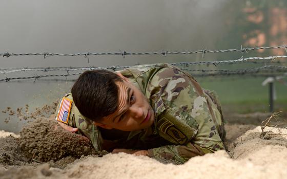 First Lt. Jim Schooley, from the 173rd Airborne Brigade, low crawls under barbed wire while participating in the obstacle course circuit during the U.S. Army Europe and Africa Best Warrior competition in Grafenwoehr, Germany, Aug. 9, 2021. Schooley won the best officer competition.