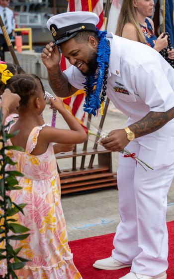 A sailor greets a little girl.