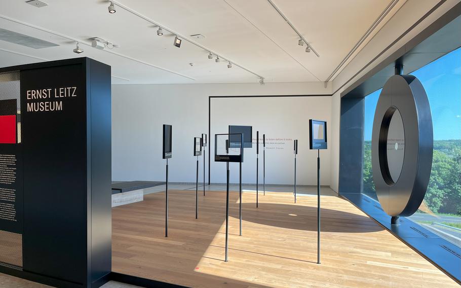 An exhibit display features a large circular structure that light can pass through. 