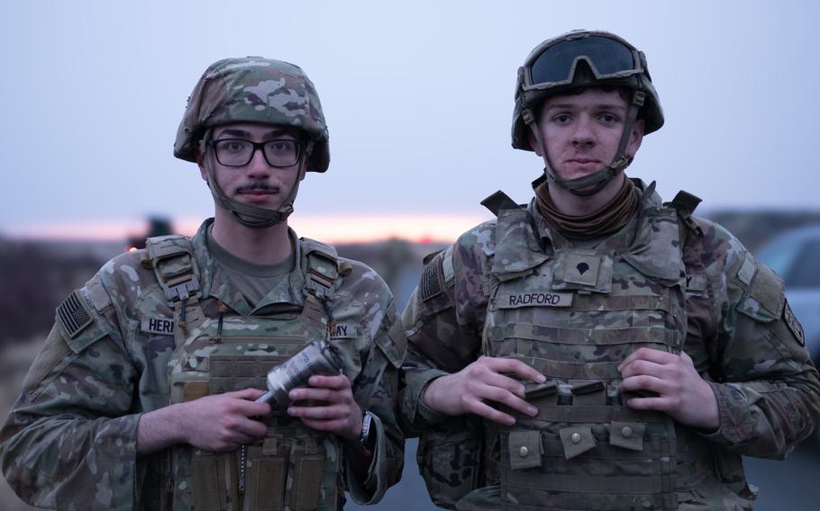Two soldiers stand next to each other.