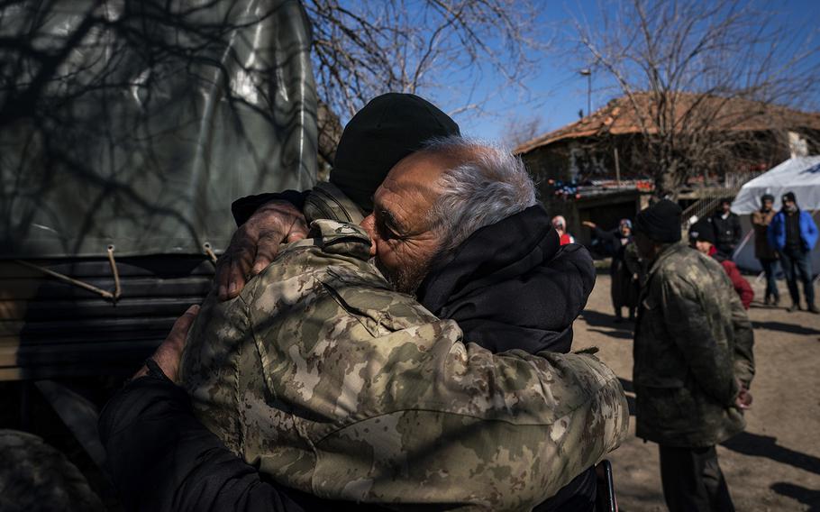 A member of the Turkish military gets a hug after delivering aid to the family of Sakine Demir in the village of Colaklar, near the town of Islahiye, Turkey, on Feb. 12, 2023. Demir and her youngest daughter, Semra, have been missing since earthquakes hit Turkey and Syria on Feb. 6. 
