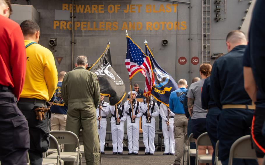 The USS Ronald Reagan's crew gathers on the flight deck to celebrate the 20th anniversary of the ship's commissioning while on patrol in the Indian Ocean, July 30, 2023. 