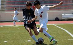 Matthew C. Perry's John Shaver and E.J. King's Christian Garcia try to play the ball during Saturday's DODEA-Japan soccer match. Shaver had the match's lone goal as the Samurai won 1-0.