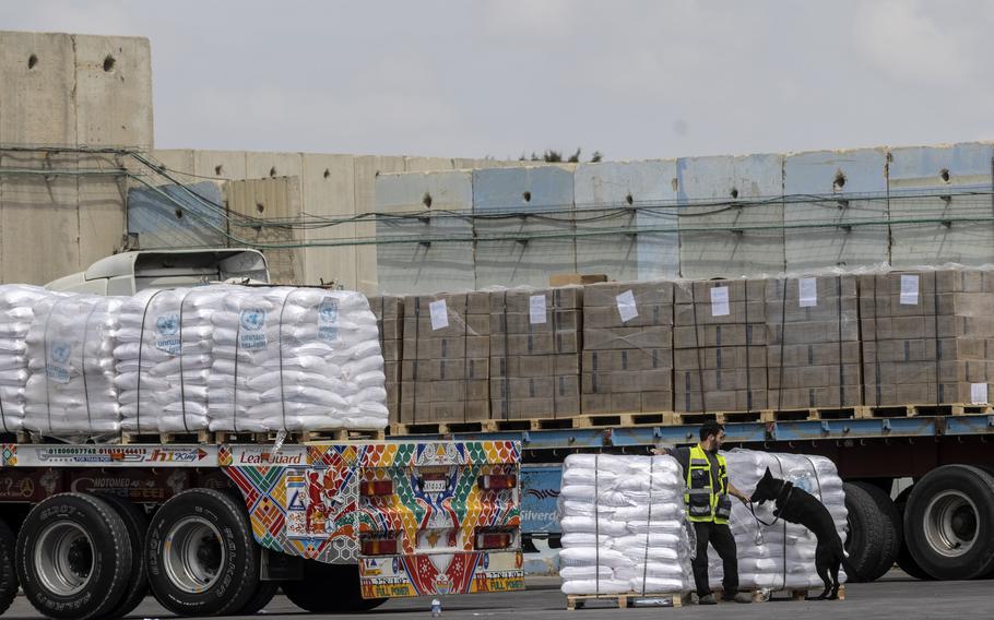 A security guard and dog inspect a truck loaded with humanitarian aid for Gaza at the Kerem Shalom border crossing last month.